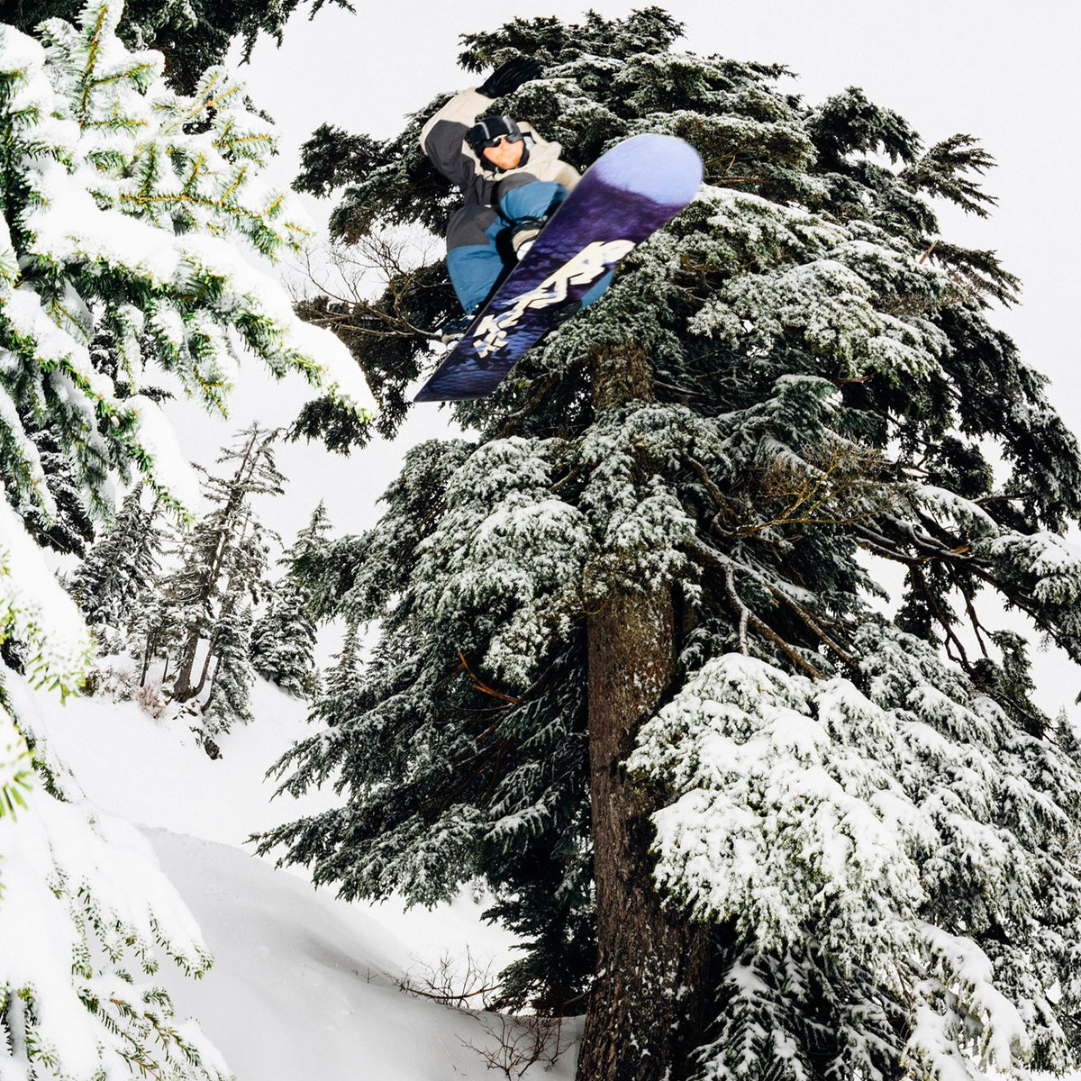 Man wearing the Thurston Power Wool™ Balaclava in black/glacier grey, on a snowy mountainside at dusk